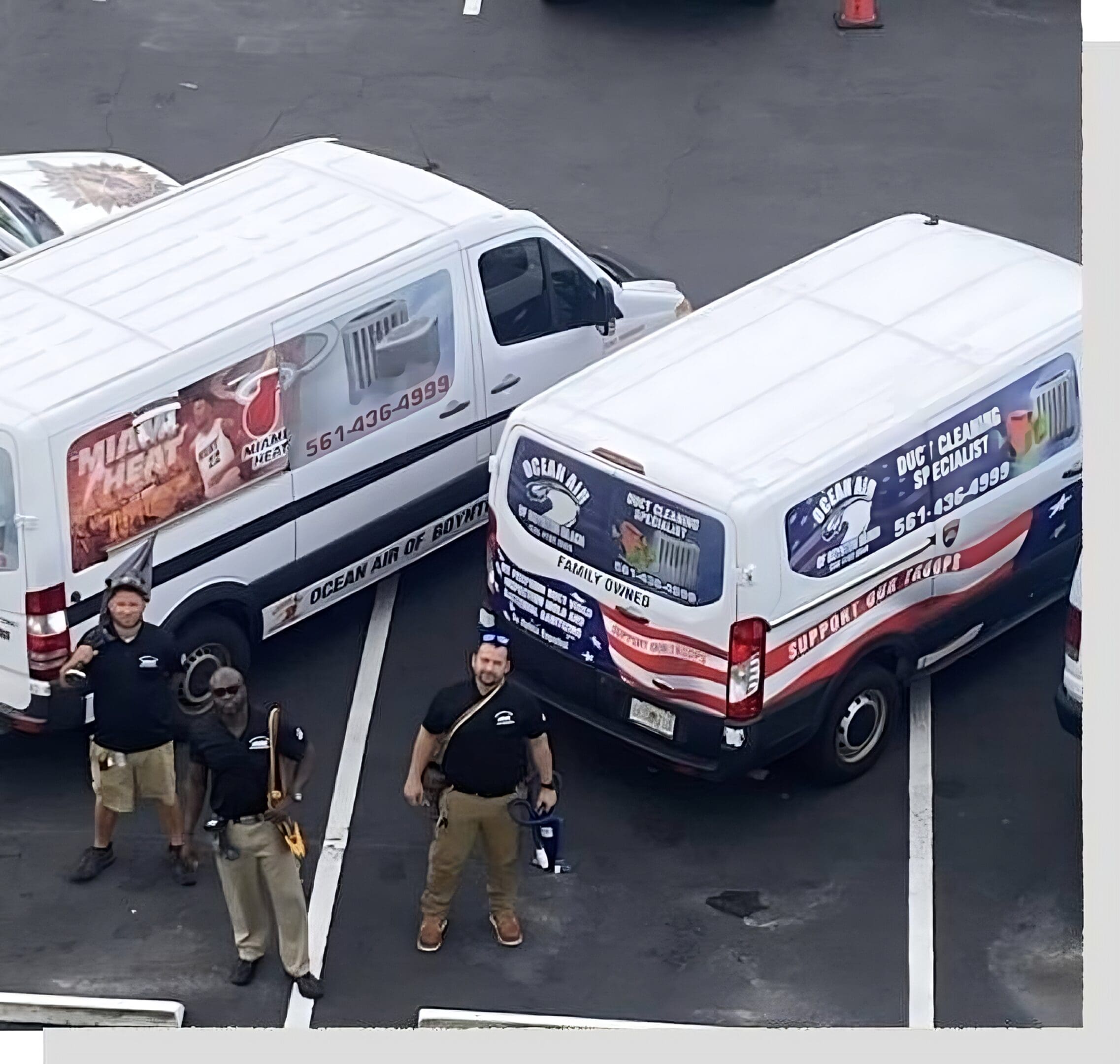 A group of men standing next to two vans.