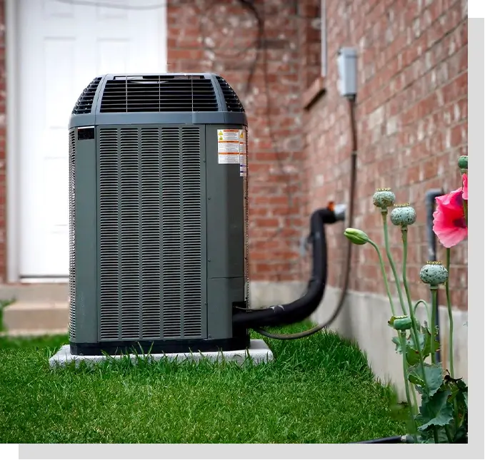 A picture of an air conditioner outside on the grass.