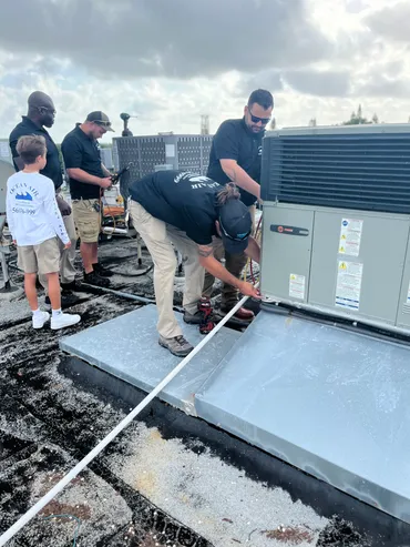 A group of people standing around on top of a roof.